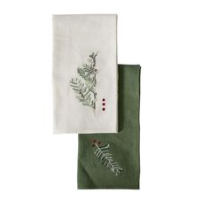 two napkins with designs on them sitting next to each other, one in green and the other in white