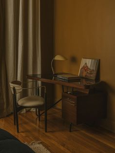 a bedroom with a desk and chair next to a window in the corner, near a bed