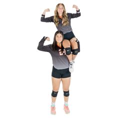 two women are posing with their arms in the air