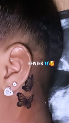 a close up of a person with butterfly tattoos on their ear