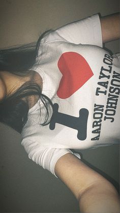 a woman wearing a white shirt with a red heart on it