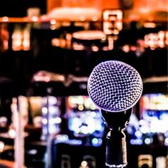 a microphone that is sitting in front of some blurry lights on the wall behind it