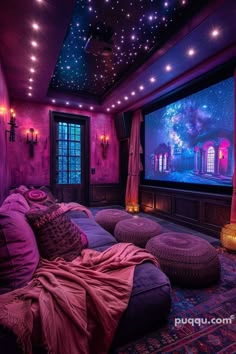 a room with purple walls and lots of pillows on the couches in front of a large screen