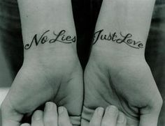 two people holding hands with tattoos on their wrists and the words no lies just love