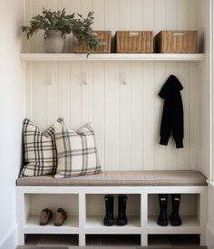 a white bench with some shoes on top of it and a coat rack in the corner