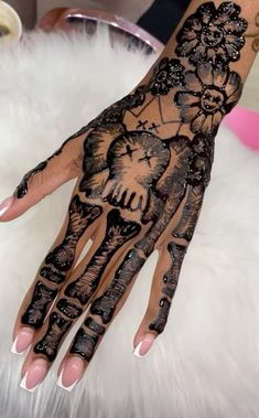 a woman's hand with an elephant and flowers tattoo on it, sitting on top of a white furnishing