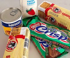 some snacks are laying out on the table next to a can of milk, chips, and yogurt