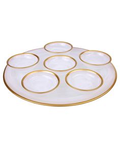 a white and gold plate with six golden rims on the bottom, sitting on a white surface