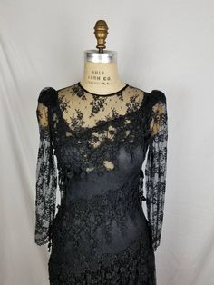 Good vintage condition Black lace Lace slip underneath 34 bust 32 waist 38 hip Has some stretch Sleeve 24 15 shoulders Fitted Lace Bodice For Evening, Stretch Lace Evening Dress, Fitted Lace Trim Dress For Party, Fitted Lace With Lace Trim For Night Out, Fitted Dresses With Delicate Lace For Evening, Lace Dress For Evening, Fitted Black Lace Dress For Wedding, Fitted Gothic Lace Top With Lace Trim, Fitted Lace Patchwork Evening Dress