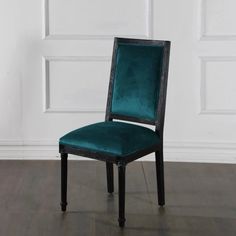 a green chair sitting on top of a hard wood floor next to a white wall