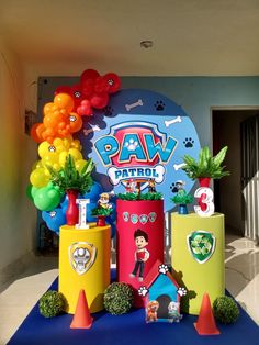 there are many decorations on the table for paw patrol birthday party with balloons and toys