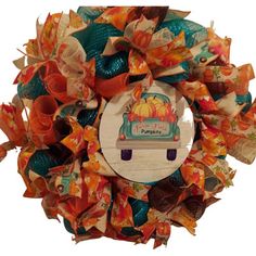 a fall wreath with pumpkins, leaves and ribbons hanging on the front of it