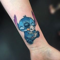 an elephant tattoo on the left wrist and right arm is blue with pink trimmings