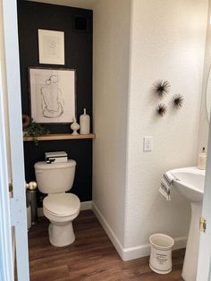 a white toilet sitting in a bathroom next to a sink