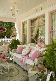 a living room filled with lots of furniture and flowers on top of it's windows