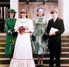 three women and two men standing on steps in front of a building, one holding a bouquet