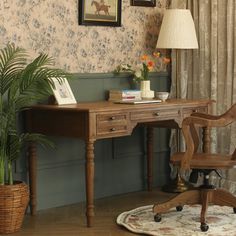 a desk and chair in a room with floral wallpaper