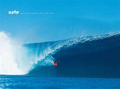 a man riding a wave on top of a surfboard in the ocean under a blue sky