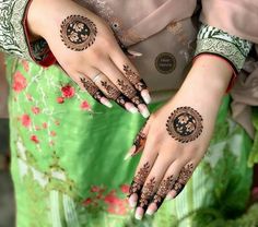 a woman's hands with henna tattoos on them