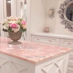 a vase filled with flowers sitting on top of a white countertop in a bathroom