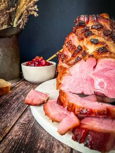 sliced ham on a plate with cranberry sauce and bread in the back ground