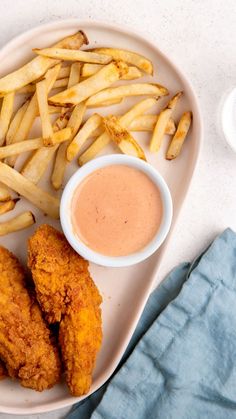 fried chicken and french fries on a plate with dipping sauce