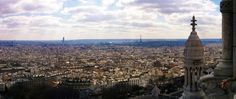 a view of the city from top of a building in paris, with clouds overhead