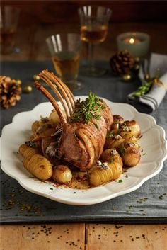 a white plate topped with meat and potatoes