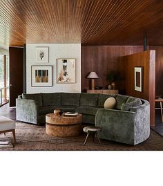 a living room filled with furniture and pictures on the wall next to a coffee table