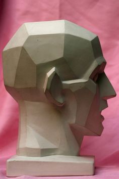 a sculpture of a man's head on a pink background