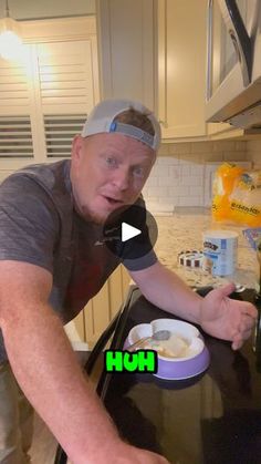 a man is making food in the kitchen with his hands and mouth wide open, while looking at the camera