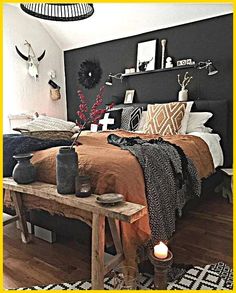 a bed room with a neatly made bed next to a wooden table and two candles