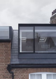 a brick building with two windows on the roof