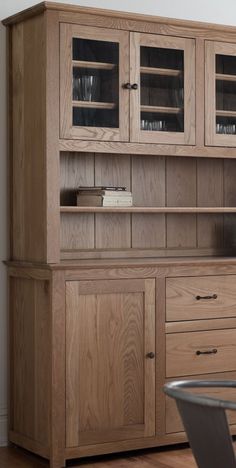 a wooden hutch with glass doors and drawers