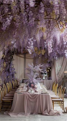 the table is covered with purple flowers and gold chairs