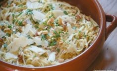 a brown bowl filled with pasta and parmesan cheese