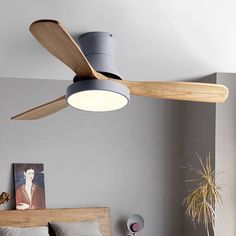 a ceiling fan that is mounted on the wall above a bed in a room with gray walls