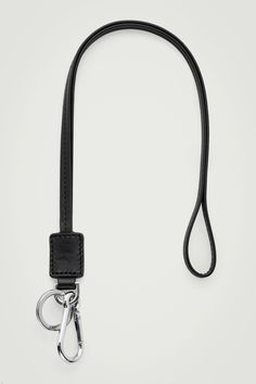 This lanyard is a pragmatic tool: it features a keyring and dog clip to keep your valuables within reach. The strap is crafted from bonded leather that's resistant to scratches and tanned classic black using chrome-free dye. Carry it around your neck or tie it to the handle of your bag. COS supports responsible manufacturing via the Leather Working Group  Shell: 100% Leather. Excluding trims Leather Key Fobs, Dog Clip, Leather Key, Key Fob, Leather Working, You Bag, Tech Accessories, Classic Black, Lanyard