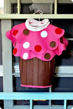 a cupcake costume is hanging on a shelf