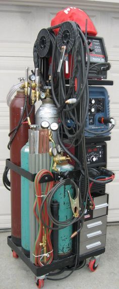 an assortment of air compressors are stacked on top of each other in front of a garage door