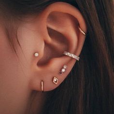 a woman's ear with three different types of piercings