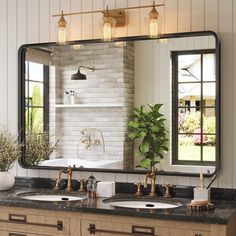 a bathroom with two sinks and a large mirror on the wall above it, along with a potted plant