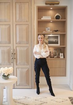 a woman is standing in front of some closets and she has her hands on her hips