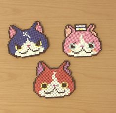 three pieces of perler bead art with cats on them, one pink and one blue