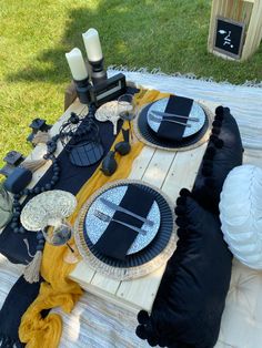 a table with black and white plates on it in the middle of a yard area