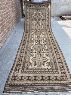 an old rug is laying on the ground in front of a brick wall and door