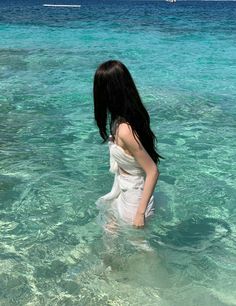 a woman is standing in the clear blue water