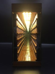 a long row of shelves in a dark room with light coming from the top one