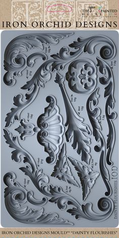 the iron - on scroll design is shown in grey and features ornate scrolls, flowers, and