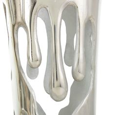 an artistic silver vase with white paint on it